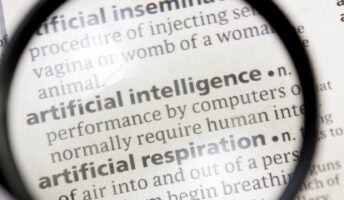 Words artificial intelligence under magnifying glass in dictionary or glossary