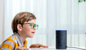 Child speaking to Amazon Echo Alexa-enabled smart speaker illustrating Alexa skills concept.