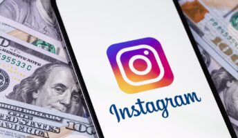 Instagram logo on iPhone against a background of dollars