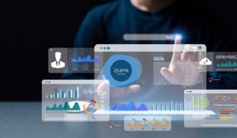 A business employee uses a computer and dashboard featuring data, statistics and other metrics